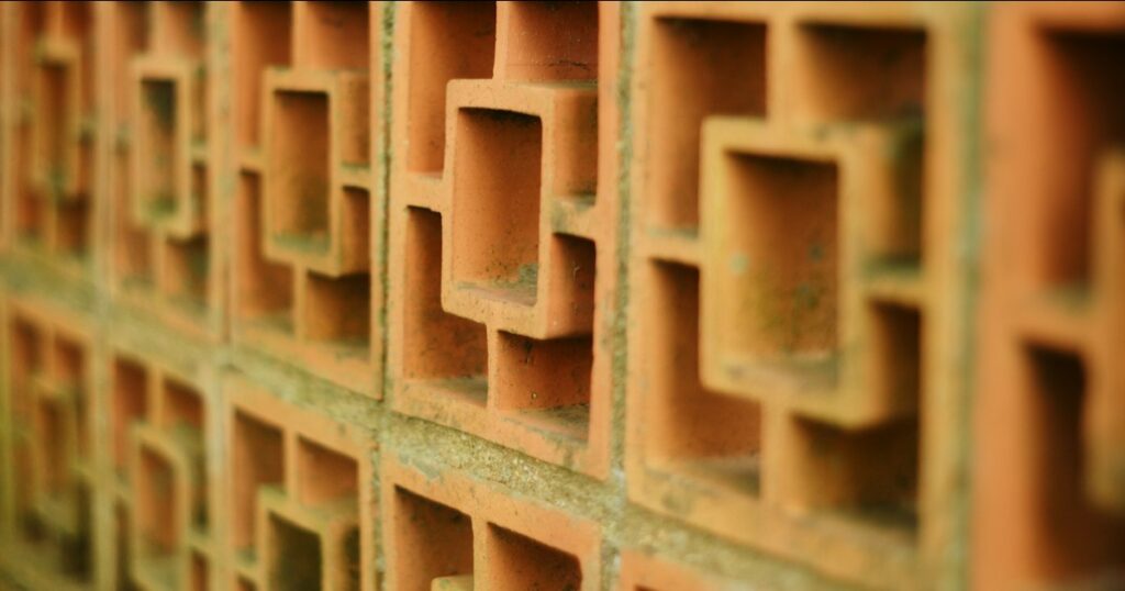 A terracotta lattice wall of repeating square openings