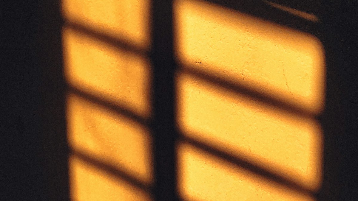 Amber window light falling across a dark wall