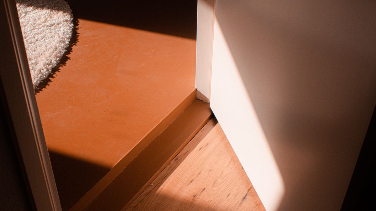 Warm sunlight falling through an open door onto a wooden floor