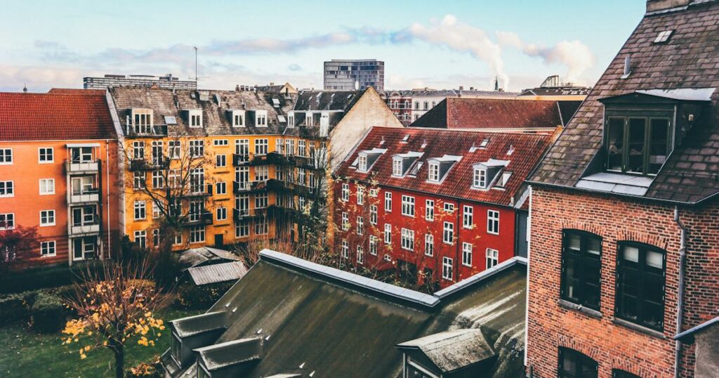 A Copenhagen courtyard in late autumn, seen from an upper window, with ochre, red and brick apartment buildings around it