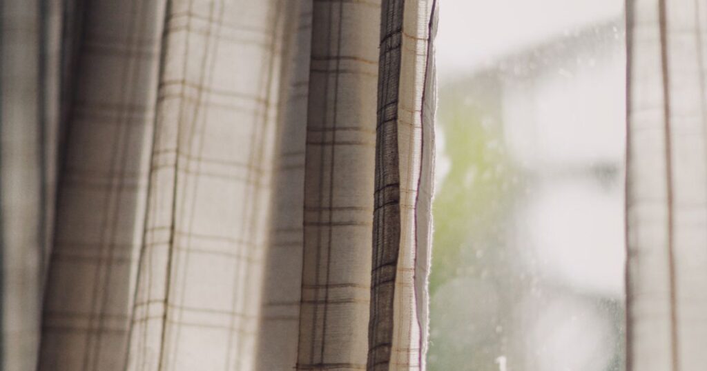 A gap between drawn curtains at a window with daylight behind them