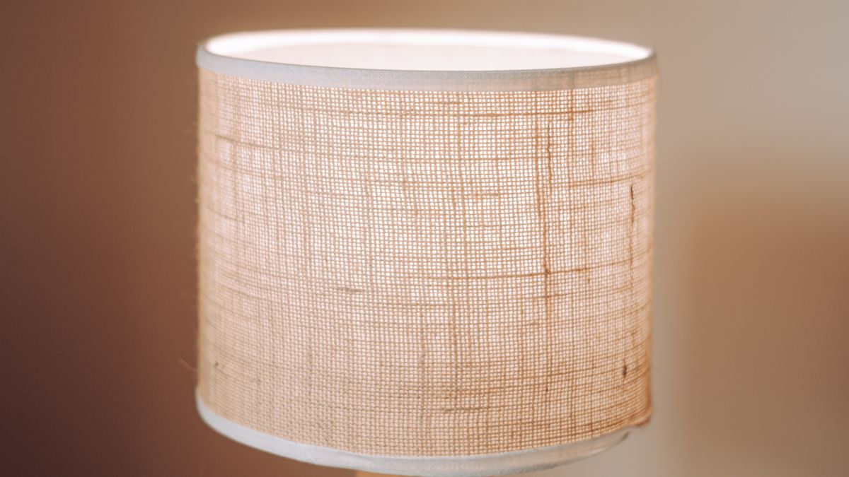 A close view of a warm linen lampshade lit softly from inside