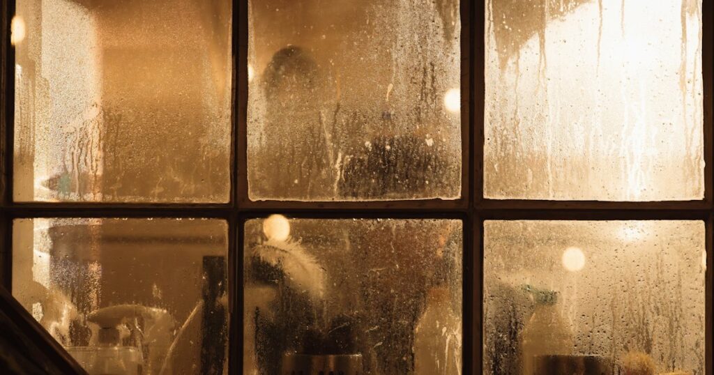 Golden light glowing through the condensation on an old multi-pane window