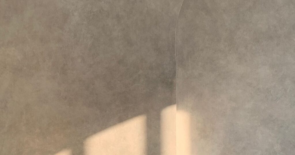 Soft daylight falling across a plain warm plaster wall